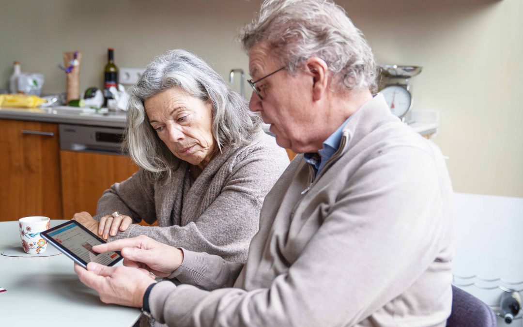 Man legt iets uit op een ipad aan vrouw